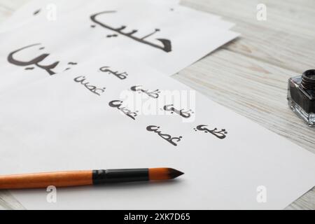 Calligraphy. Papers with word Branch in Arabian language and brush on white table, closeup Stock Photo