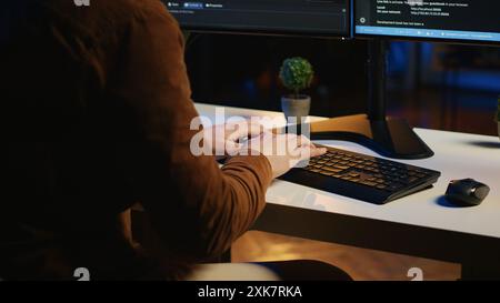 Software developer impatiently spamming malfunctioning keyboard buttons, trying to write lines of code in home office. Irritated IT professional having trouble with computer peripheral, close up Stock Photo