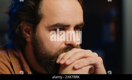 Programmer in home office concentrating on finding bugs while doing coding on computer, extreme close up shot. IT admin frowning while looking at screen, confused by errors in lines of code, camera A Stock Photo