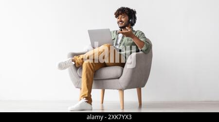 Positive handsome indian having video conference, using notebook Stock Photo
