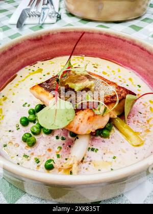 Top view of Irish cod fish fillet dish with peas and white sauce. Stock Photo
