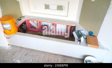 Framework for a new bath and freshly plastered walls with tradies gear around it Stock Photo