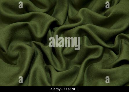 Green fabric background. Green cloth waves background texture. Green fabric cloth textile material. Stock Photo