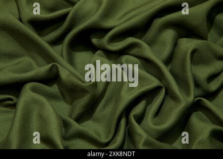 Green fabric background. Green cloth waves background texture. Green fabric cloth textile material. Stock Photo