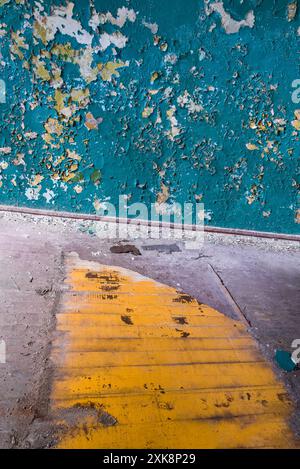 Peeling Off Azure Paint Wall Background In Old Broken Abandoned Empty Room With Bright Yellow Board Floor Stock Photo