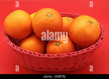 Fresh oranges isolated on red background. Stock Photo