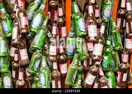 Wall decorated with garland of old empty beer bottles Stock Photo