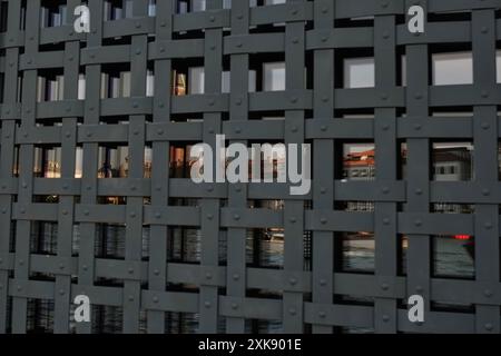 Punta della Dogana, Venice, Campanile & the Domes St Marks a glossy reflection in a glass window behind a riveted, iron lattice grill at Customs House Stock Photo