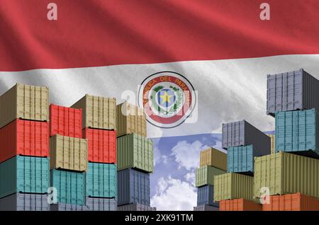 Paraguay flag and big stack of shipping cargo containers in docks with sky background close up Stock Photo