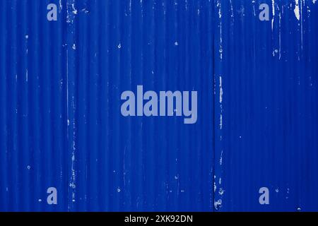 Old corrugated metal panel wall painted in a blue paint. Old weathered wall background concept. Stock Photo