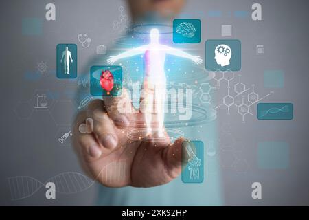 Man on blurred background using digital x-ray human body holographic scan projection 3D rendering. Doctor hand show a hologram of the patient on a blu Stock Photo