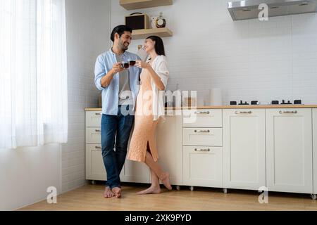 Beautiful couple drinking coffee or tea on the modern terrace in mountains. Copy space. Happy couple drinking coffee and making plans for the day whil Stock Photo