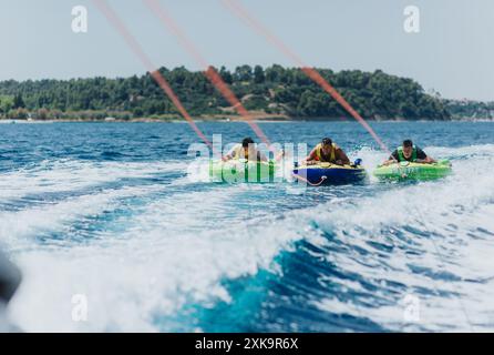 Exciting summer tubing adventure behind a speedboat on the sea Stock Photo