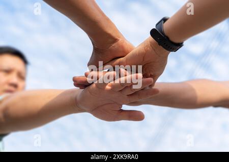 Close up low angle of business people putting their hands together. Stack of hands. Unity and teamwork concept. Group of people stacking hands togethe Stock Photo