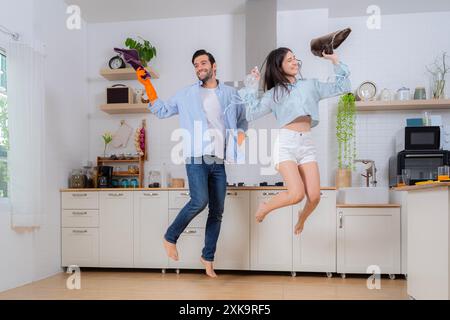 Hygiene, household chores in spare time. Young family couple doing cleaning in the house. Cleaning concept. Cheerful young european lady and male wash Stock Photo