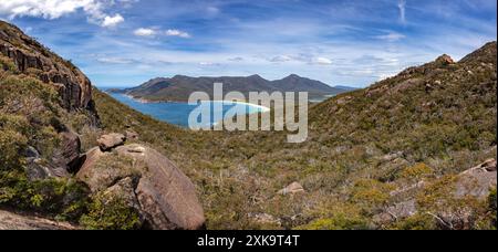 Panorama of the rocky outcrops on The Hazards in Freycinet National park, with Wineglass bay, Mount Graham and Mount Freycinet in the distance. Summer Stock Photo