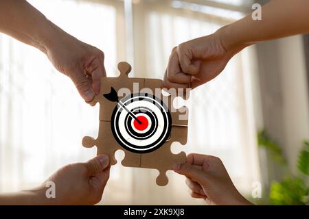 Stakeholder, business connection, teamwork, and team building concept. Close-up wooden figure, as businessman on jigsaw puzzles with target icon symbo Stock Photo