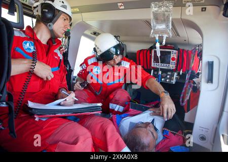 A doctor and paramedic inside a rescue helicopter. They are helping an injured hiker. Air Zermatt in the Swiss Alps is one of the busiest and most professional rescue services in t Stock Photo
