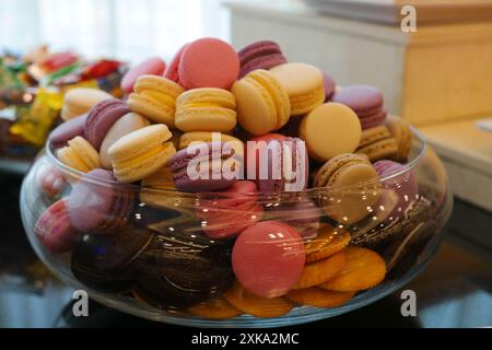 Assorted macaroons in a glass bowl on a table. Stock Photo