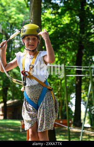 Young adventurer navigating a treetop obstacle course, demonstrating courage and determination. Stock Photo