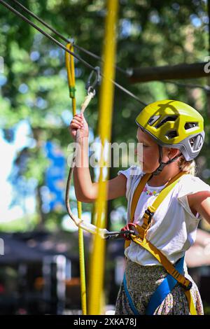 Young adventurer navigating a treetop obstacle course, demonstrating courage and determination. Stock Photo