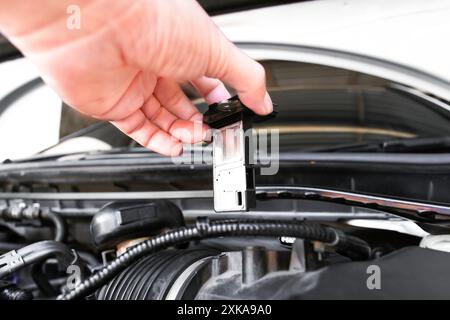 Mass air flow sensor in a hand of air intake manifold in the car engine , Automotive parts concept Stock Photo