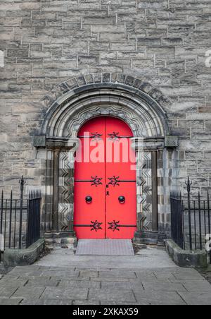 Edinburgh, Scotland - Jan 16, 2024 - Facade of arched red wooden doorway on stone wall of Mansfield Traquair Centre in Edinburgh. Scotland. Copy space Stock Photo