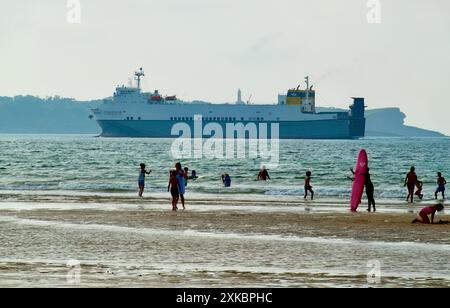 Ro-Ro cargo ship Melusine arriving to the port of Santander with El Faro lighthouse seen from the beach of Somo Ribamontán al Mar Cantabria Spain Stock Photo