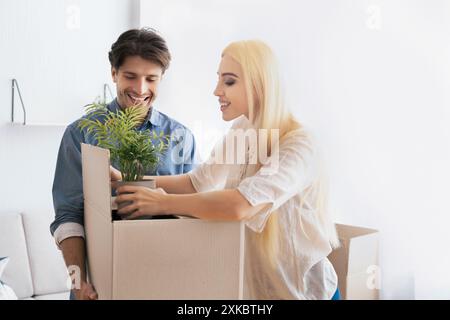Cheerful Spouses Packing Things In Moving Boxes Preparing For Relocation Stock Photo