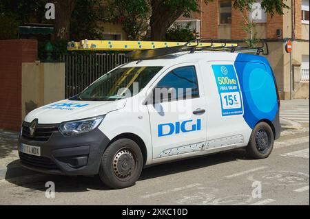 Viladecasn, SPAIN - JULY 22, 2024: A white van with DIGI advertising parked on a city street. The van, which has a ladder on the roof, appears to be u Stock Photo