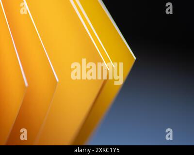 Vibrant yellow cardstock geometric angles against a blue and black background Stock Photo