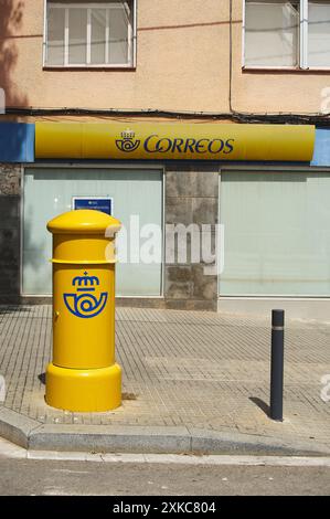 Viladecasn, SPAIN - JULY 22, 2024: Featured image of a yellow Post Office mailbox on a Spanish street, symbolizing the daily postal service in urban l Stock Photo