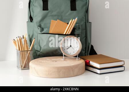 School backpack and school stupplies with space for products on wooden desk on white wall background. Back to school concept. Copy space Stock Photo