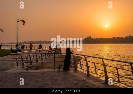 The Saudi people watching sunset on the Al Hamra Corniche in Jeddah waterfront, Saudi Arabia, during the beautiful colorful Middle East sunset. Stock Photo