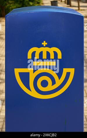 Viladecasn, SPAIN - JULY 22, 2024: Image of a blue postal mailbox featuring a yellow emblem of a crown, located outdoors. This mailbox is used by post Stock Photo