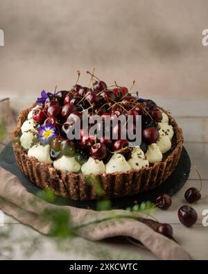 Cherry tart with cream on the wooden table. Celebration tart. Stock Photo
