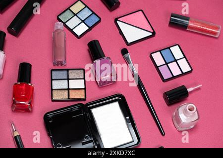 Various decorative cosmetics and brushes on a pink background. Stock Photo