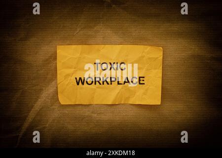 A crumpled paper note with the words Toxic Workplace on it. Close up. Stock Photo