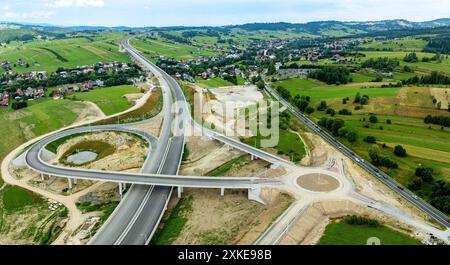 New fragment of highway under construction on Zakopianka road, Poland, over Klikuszowa village. Entrance and exit ramps, traffic circle. State in July Stock Photo