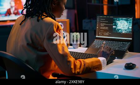 African american girl uses artificial intelligence software for machine learning and cloud computing, terminal window programming language. IT student studying deep learning AI hardware. Camera A. Stock Photo