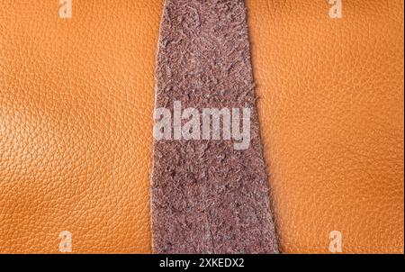 Close-up photo texture of light brown colored leather roll with suede strap. Stock Photo
