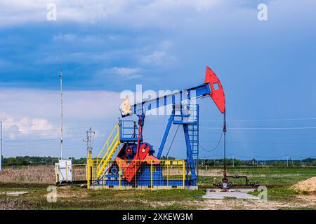 Oil drilling derrick pumps oil from ground. Petroleum industry, crude oil extraction. Production of fuel from natural resources. Oil crisis. Stock Photo