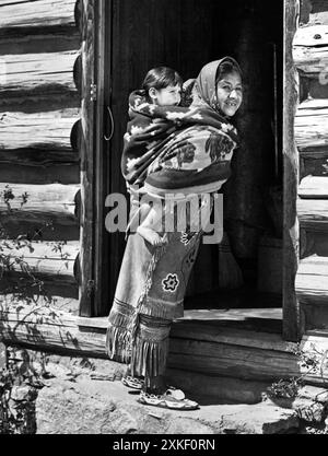 North Carolina  1946 This Cherokee woman still likes the papoose method of carrying her child. She is a supporter of HB 1121, which will limit tribal membership to those with more than 1/16th Cherokee blood,  to  prevent 'White Indians' from making claims on reservation land in the Qualla Boundary in the Smoky Mountains. Stock Photo