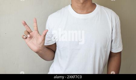 A man in casual clothes showing three fingers while counting Stock Photo