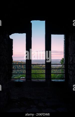 View through a window in the ruins of Hohenbaden Castle at sunrise over the Rhine Valley and the Vosges Mountains, Baden-Baden, Germany Stock Photo