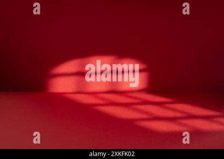 Abstract red studio background with sun light trails, Backdrop with shadows of a window for product display  defocused Stock Photo