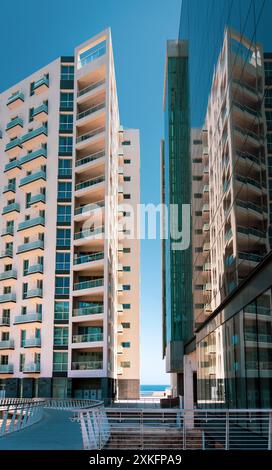 Contemporary high-rise buildings with reflective glass surfaces under a clear blue sky on a sunny day. Urban architectural photography highlighting mo Stock Photo