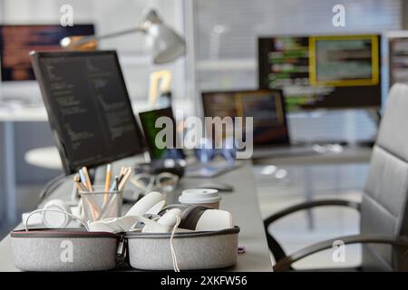 Background shot of contemporary computer programmer office setup with VR headset in carrying case on desk, copy space Stock Photo