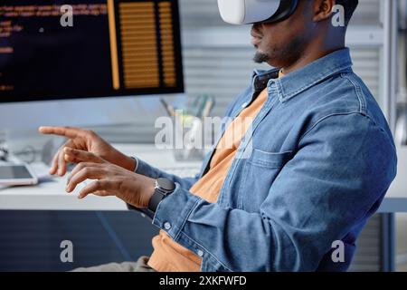 Cropped side view of concentrated male African American software engineer coding in headset using VR systems at office workplace, copyspace Stock Photo