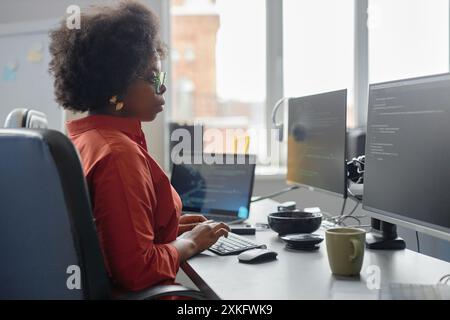 Side view shot of young focused female African American software developer in glasses Stock Photo